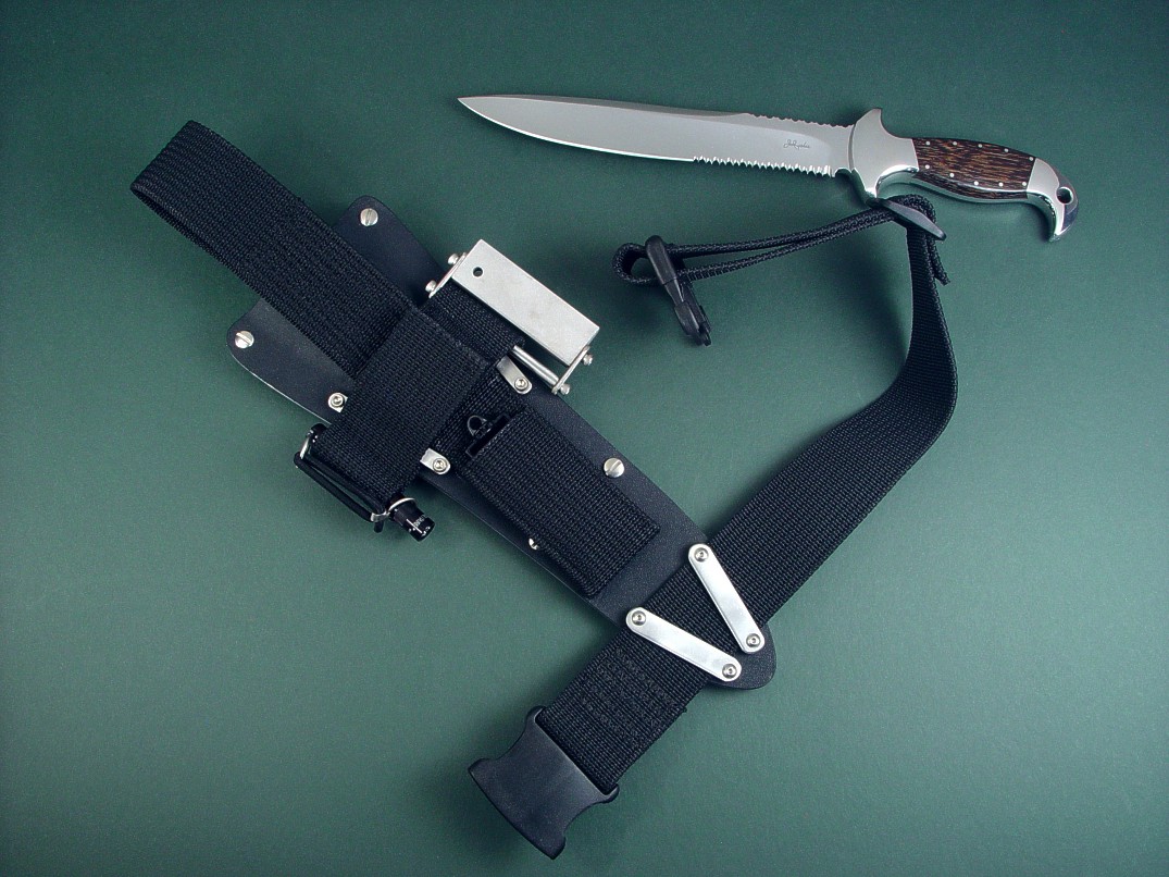 "Macha EL" obverse side view in 440C high chromium stainless steel blade, 304 stainless steel bolsters, Black Palm Wood hardwood handle, sheath in kydex, aluminum, stainless steel with ultimate belt loop extender in polypropylene, nylon, stainless steel, Maglite Solitaire, Magnesium/Firesteel fire starter, diamond pad sharpener, quick release thigh belt "Macha EL" obverse side view in 440C high chromium stainless steel blade, 304 stainless steel bolsters, Black Palm Wood hardwood handle, sheath in kydex, aluminum, stainless steel with ultimate belt loop extender in polypropylene, nylon, stainless steel, Maglite Solitaire, Magnesium/Firesteel fire starter, diamond pad sharpener, quick release thigh belt
